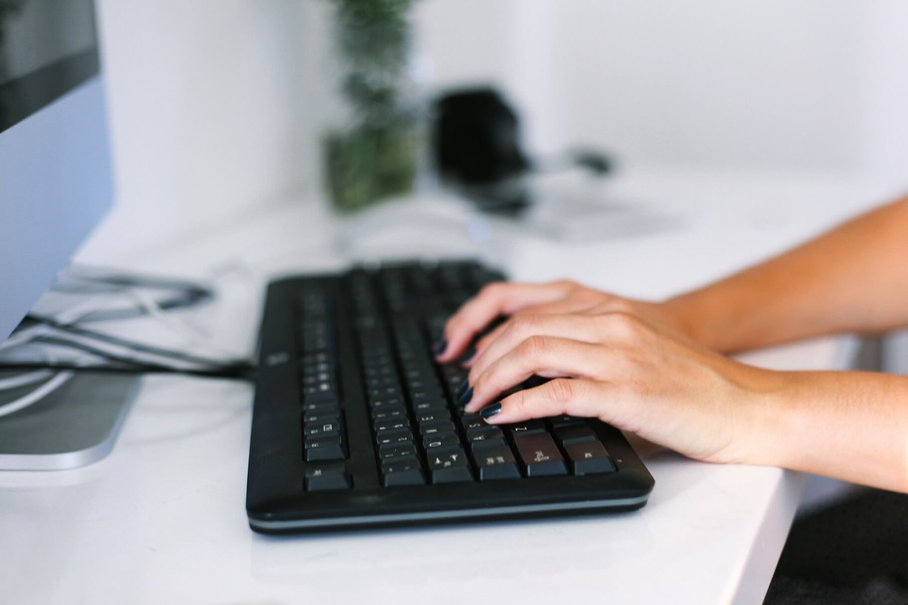 womans-hands-typing-on-keyboard-at-desk-working-in-JDKKPMP.jpg